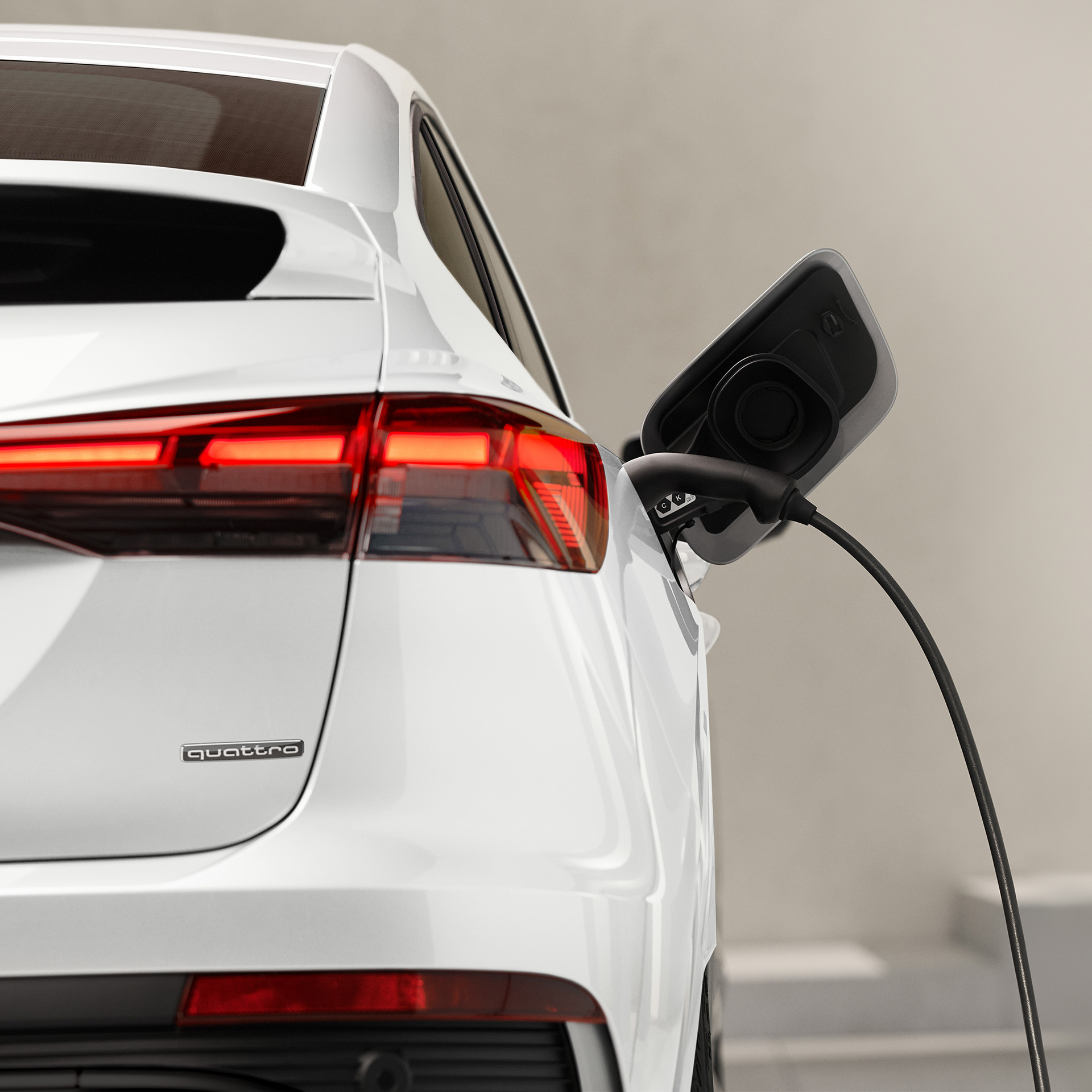 Close-up of a white Audi Q4 e-tron charging. 