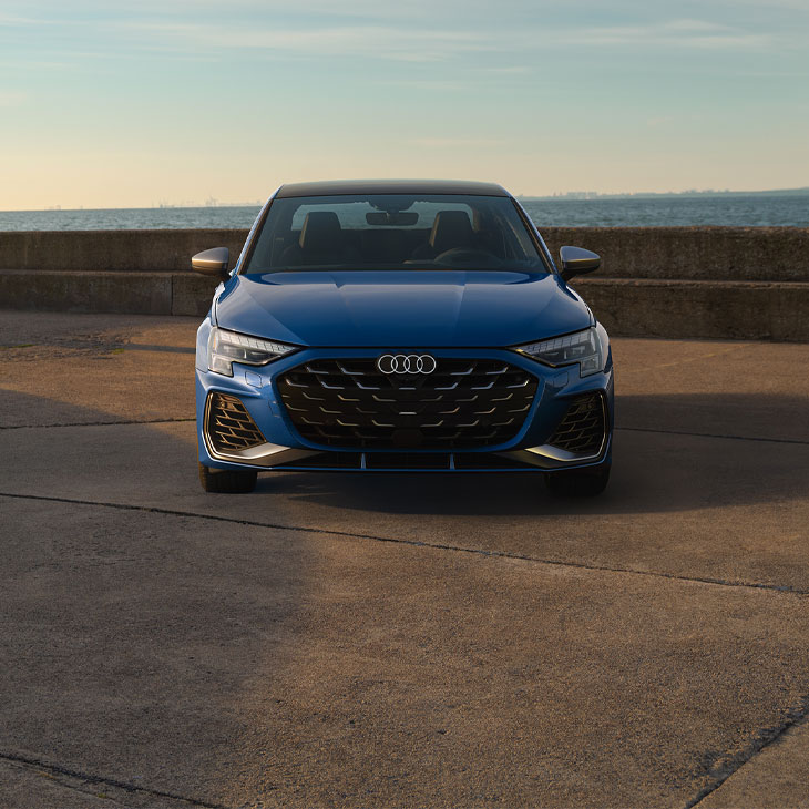 Front profile of a blue Audi S3 parked.