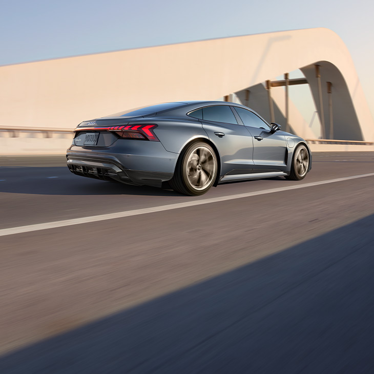 Three-quarter rear view of the Audi e-tron GT accelerating. 