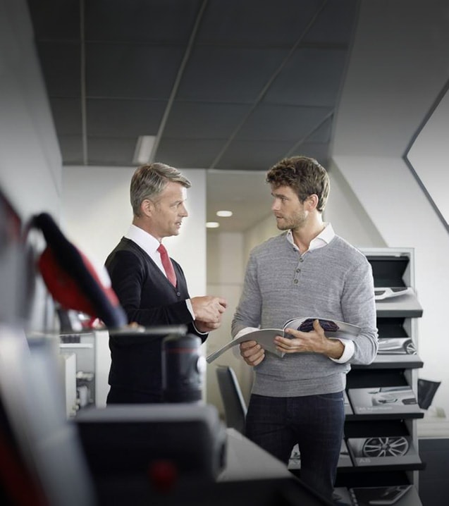 Audi employee and owner having a conversation.