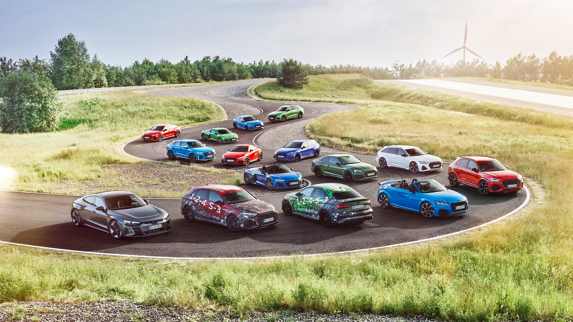 Aerial view of a collection of Audi Sport models parked on a race track.