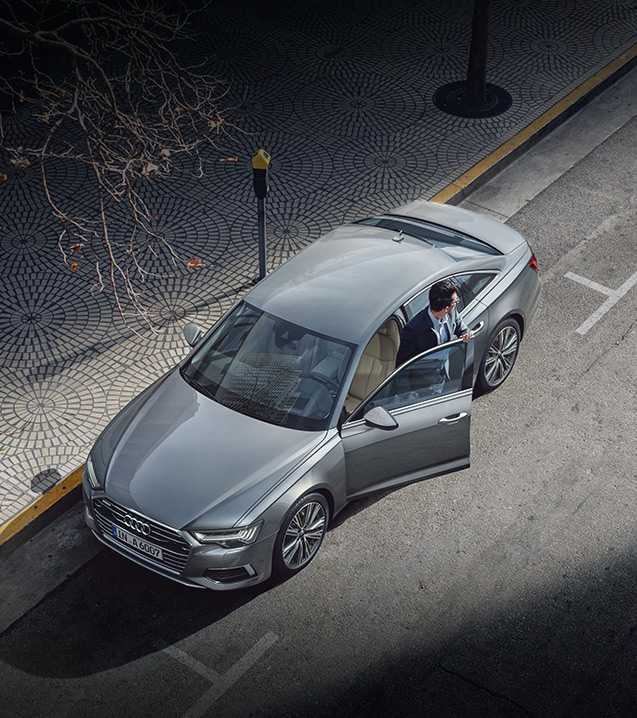 Aerial view of a person stepping out of an Audi vehicle.