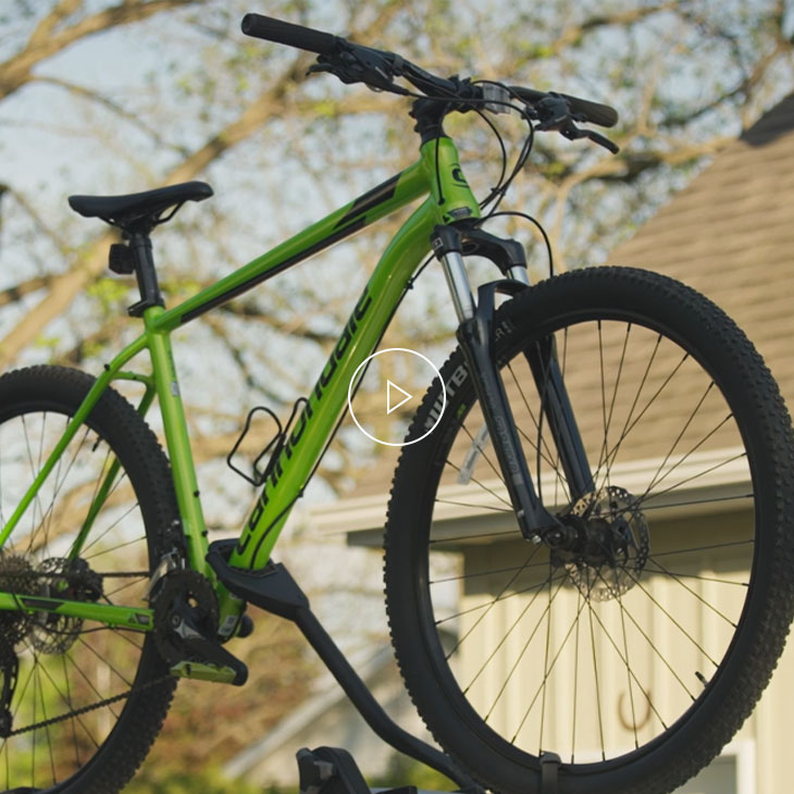 A green bike attached to the roof of a vehicle. 