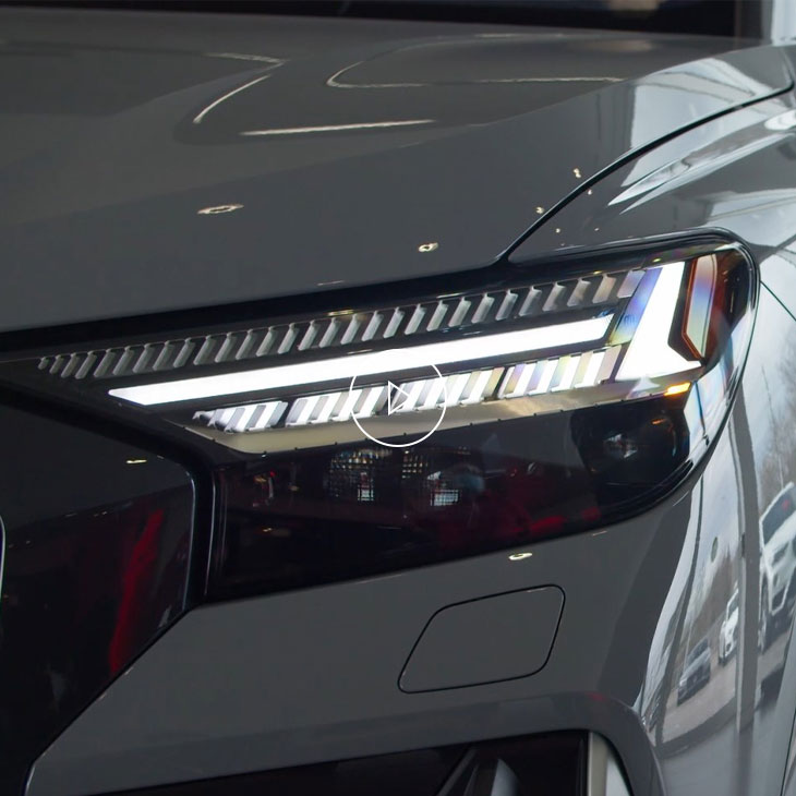 Close-up of the headlight of an Audi vehicle displaying a custom light signature. 