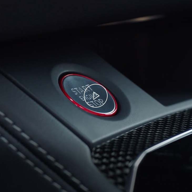  Close-up photo of the Stop-start engine button inside an Audi vehicle. 