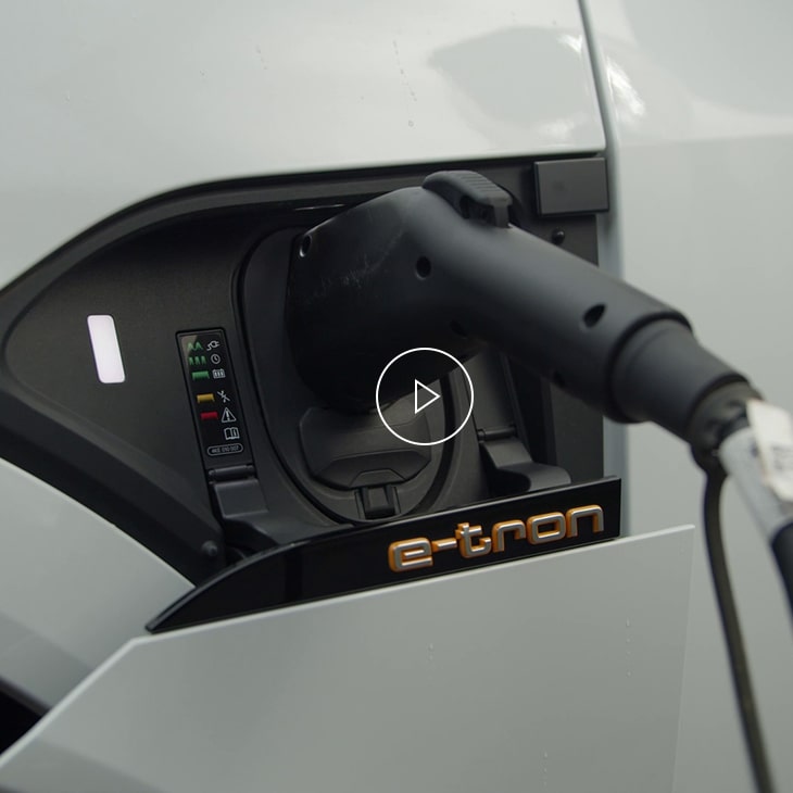 Close-up photo of the charging port of an Audi e-tron vehicle. 