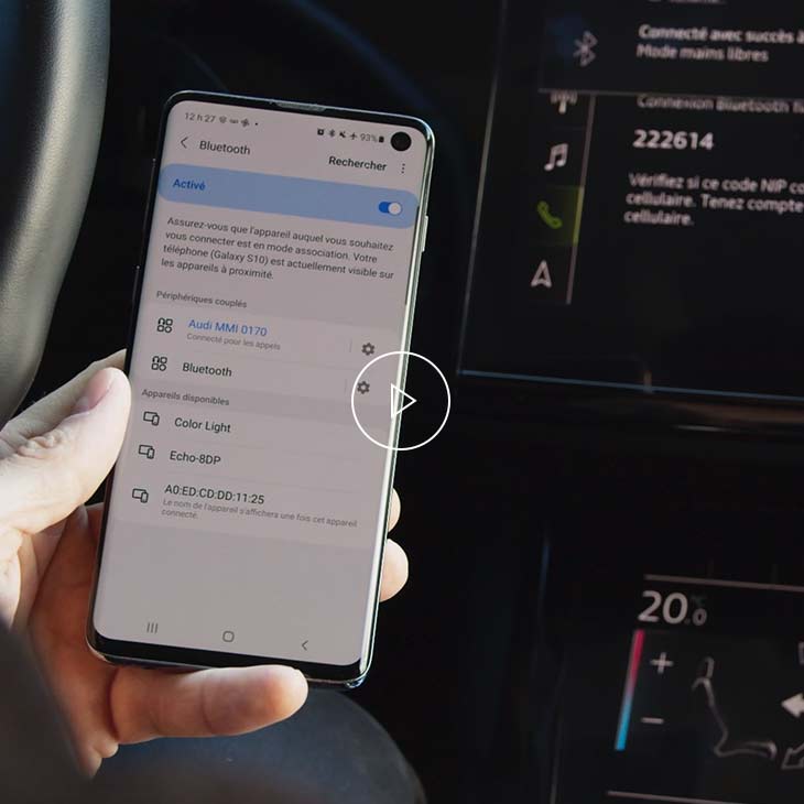  Gros plan d’une personne jumelant son téléphone cellulaire à son véhicule Audi par Bluetooth. 