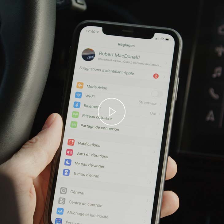  Gros plan d’une personne réglant les paramètres de CarPlay sur un iPhone.