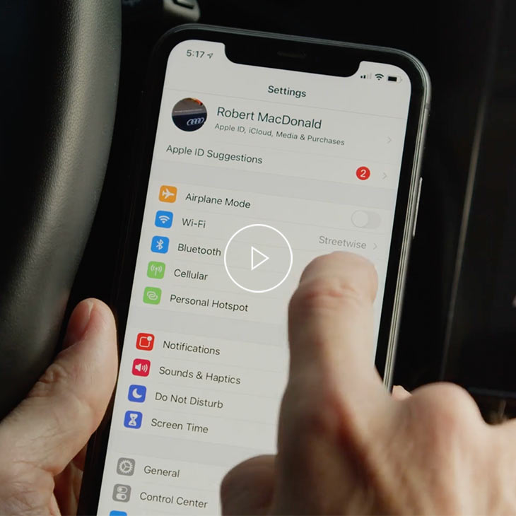  Close-up photo of a person adjusting the CarPlay settings of an iPhone.