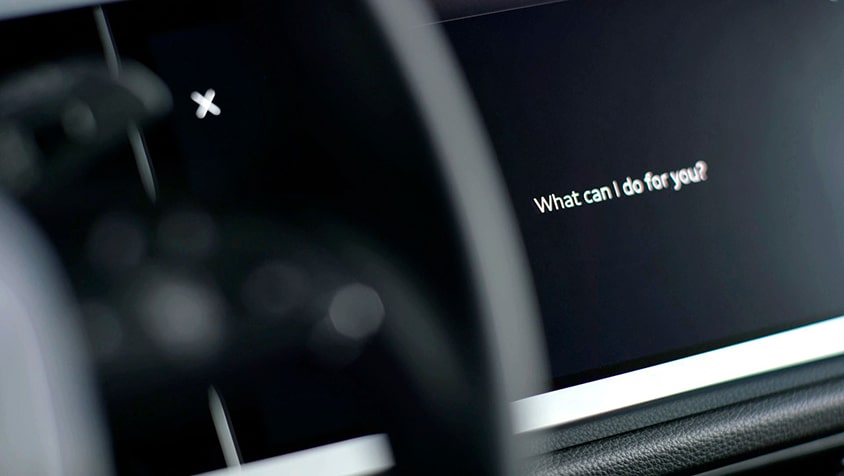 View of the Audi MMI displaying the voice recognition prompt "What can I do for you?"
