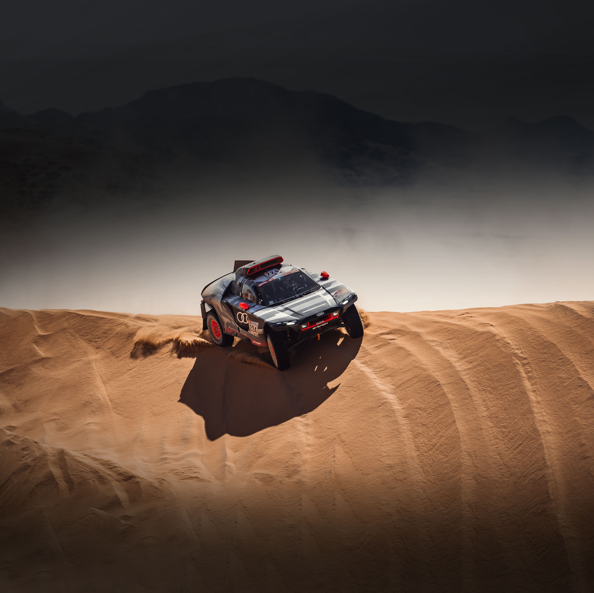 An Audi RS Q e-tron tackles a sand dune in the 2022 Dakar Rally. 