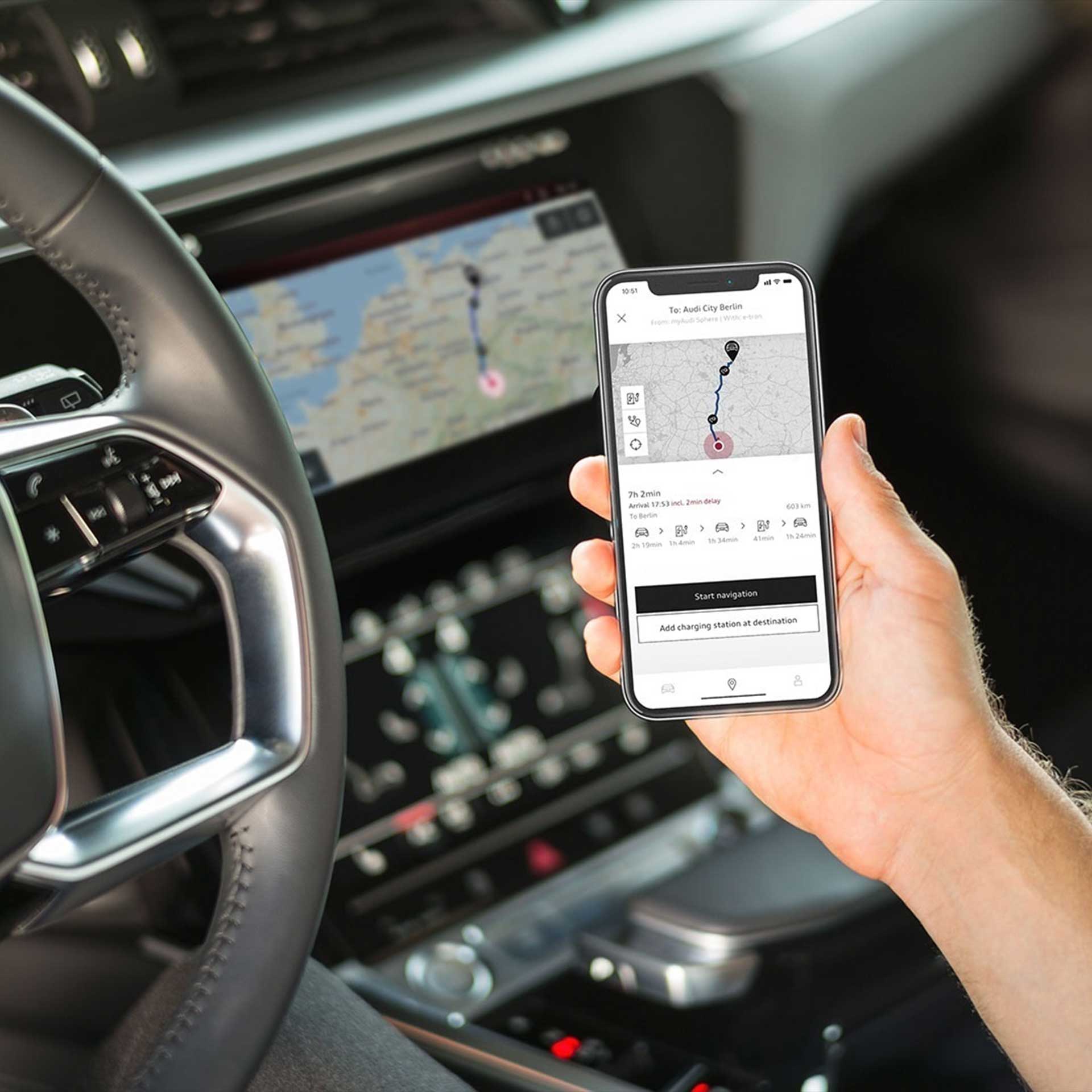 A person sitting in the driver's seat while using the Audi e-tron route planner feature in the myAudi app.