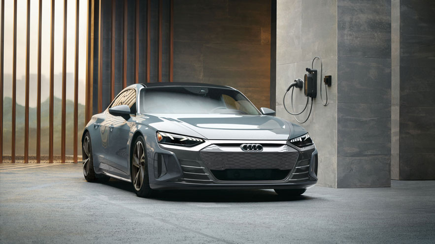 Vue de trois quarts avant d'une Audi e-tron GT garée dans un parking.